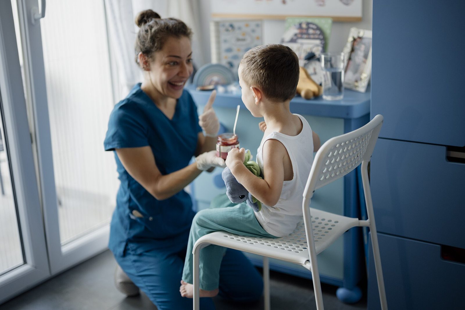 Una dentista atiende a un niño sonriente en el consultorio.